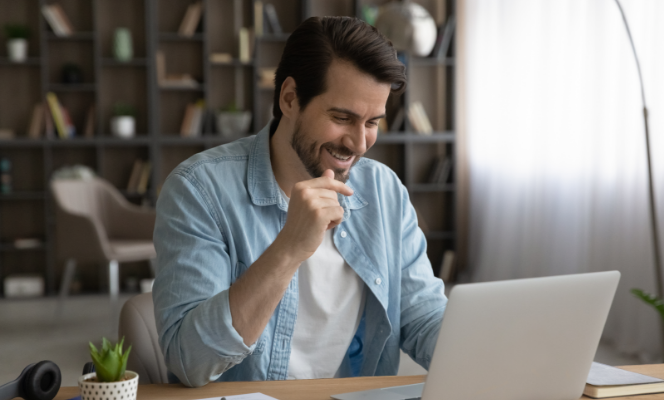 Man smiling while using laptop